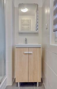 a bathroom with a sink and a mirror at Les Peupliers Appart de Charme in Compiègne