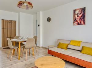 a living room with a couch and a table at Les Peupliers Appart de Charme in Compiègne