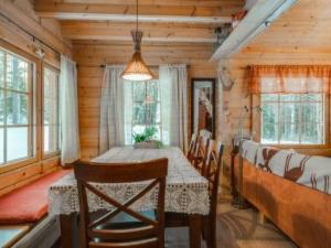 a dining room with a table and chairs and windows at Holiday Home Ahonranta by Interhome in Juntusranta