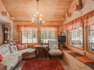 a living room with a couch and a table and windows at Holiday Home Ahonranta by Interhome in Juntusranta +25 photos