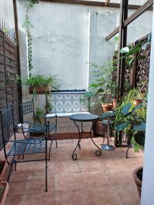 a patio with a table and chairs and a bench at Casa Consell Bailen, Guest House in Barcelona