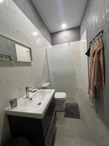 a white bathroom with a sink and a toilet at MiTRa Luxury Apartments in Shumen +50 photos