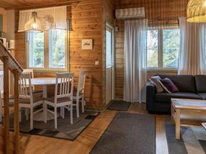 a living room with a table and chairs and a couch at Holiday Home Noukatti by Interhome in Lahdenperä