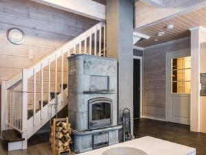 a fireplace in a living room with a staircase at Holiday Home Leimu a by Interhome in Vuokatti
