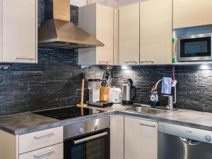 a kitchen with a sink and a microwave at Holiday Home Leimu a by Interhome in Vuokatti +17 photos
