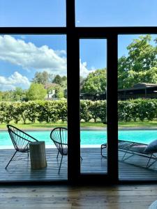 two chairs sitting on a porch next to a swimming pool at LOFTS de FREIXAS in Pilar +36 photos