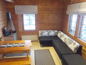 a living room with a couch and a table at Holiday Home Aili by Interhome in Arrakoski +6 photos