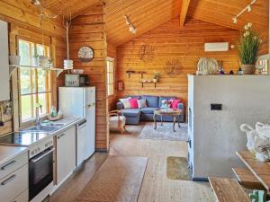 a kitchen and living room in a log cabin at Holiday Home Annas beach by Interhome in Haminankylä