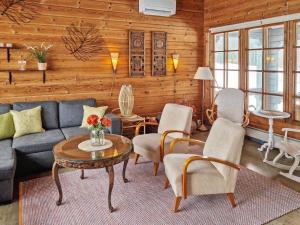 a living room with a couch and chairs and a table at Holiday Home Annas beach by Interhome in Haminankylä +21 photos