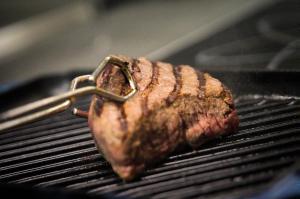 a piece of meat is cooking on a grill at Nice studio in 16th century castle in Aywaille
