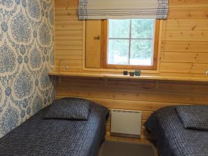 a bedroom with two twin beds and a window at Holiday Home Aaretti by Interhome in Arrakoski +6 photos