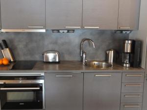 a stainless steel kitchen with a sink and a stove at Holiday Home Aaretti by Interhome in Arrakoski