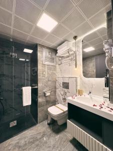 a bathroom with a toilet and a sink and a shower at Alberello Otel in Kütahya