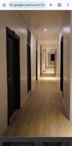 a hallway with a long corridor with black doors at Platinum Inn Bukitbintang in Kuala Lumpur