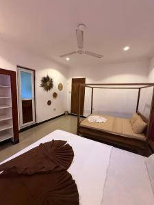 a bedroom with a bed and a ceiling fan at Lemon Lodge Nungwi in Nungwi