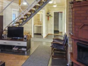 a living room with a television and a staircase at Holiday Home Tervaleppä by Interhome in Torvoila