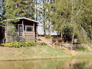 a small cabin with a porch next to a body of water at Holiday Home Hellinki by Interhome in Vaskivesi