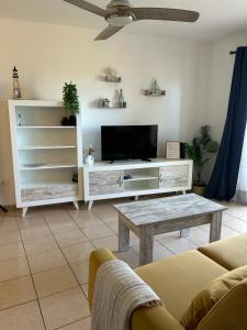 a living room with a tv and a couch and a table at Apartamento tranquilo con vistas in Los Realejos