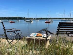 a table with a plate of food and boats in the water at The Boathouse in Waldringfield +17 photos