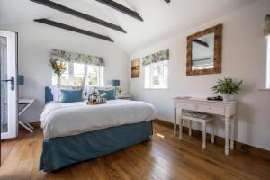 a bedroom with a bed and a table and a mirror at The Boathouse in Waldringfield