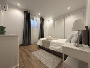 a bedroom with a bed and a desk and a window at Casinhas do Penedo in Canelas +19 photos