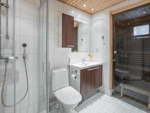 a bathroom with a toilet and a shower and a sink at Holiday Home Yllästar 3 as 616 by Interhome in Äkäslompolo +3 photos