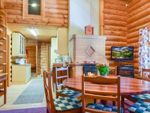 a kitchen and dining room with a table and a fireplace at Holiday Home Kivitasku by Interhome in Kallionkieli