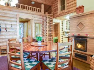 a dining room with a table and chairs and a fireplace at Holiday Home Kivitasku by Interhome in Kallionkieli