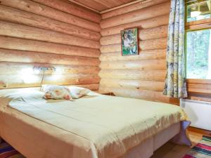 a bedroom with a bed in a log cabin at Holiday Home Kivitasku by Interhome in Kallionkieli +30 photos