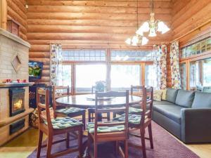 a living room with a table and chairs and a couch at Holiday Home Kivitasku by Interhome in Kallionkieli
