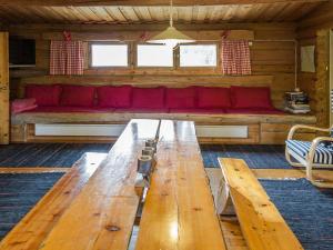 a wooden table in a room with a red couch at Holiday Home Miilumaja by Interhome in Äkäslompolo