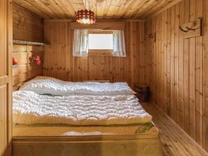 a bedroom with a bed in a wooden cabin at Holiday Home Miilumaja by Interhome in Äkäslompolo