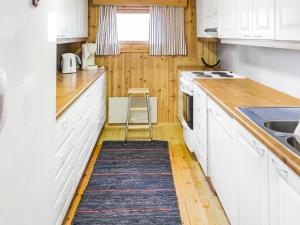 a kitchen with white cabinets and a stool in it at Holiday Home Miilumaja by Interhome in Äkäslompolo +13 photos
