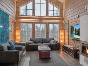 a living room with two couches and a tv at Holiday Home Sopukka by Interhome in Vuokatti