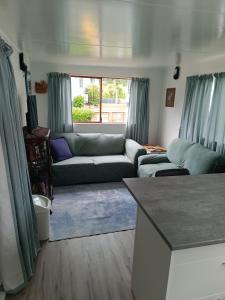 a living room with a couch and a window at Coro Coast getaway in Te Puru