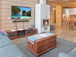 a living room with a tv and a fireplace at Holiday Home Sopukka by Interhome in Vuokatti +45 photos