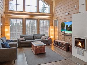 a living room with a fireplace and a tv at Holiday Home Sopukka by Interhome in Vuokatti