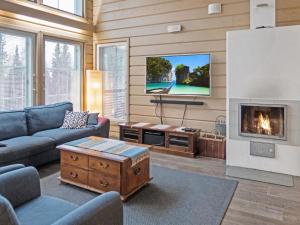 a living room with a fireplace and a tv at Holiday Home Sopukka by Interhome in Vuokatti