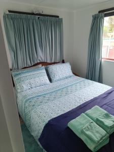 a bedroom with a bed with two towels on it at Coro Coast getaway in Te Puru