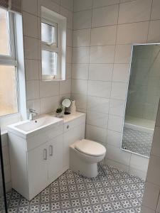 a white bathroom with a toilet and a sink at 2 bed apartment close to beach in Herne Bay +30 photos