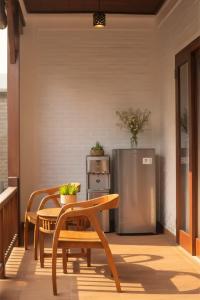 a patio with a table and a stainless steel refrigerator at Kubu Daje - Comfortable New Villa in Canggu in Dalung