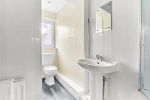 a white bathroom with a toilet and a sink at Suggitt House in Hartlepool