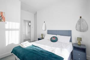 a bedroom with a large bed and two blue night stands at Suggitt House in Hartlepool