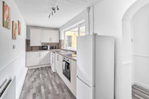 a kitchen with white cabinets and a refrigerator at Suggitt House in Hartlepool +3 photos