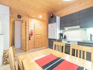 a kitchen with a wooden table and a kitchen with a refrigerator at Holiday Home Simeoni by Interhome in Äkäslompolo