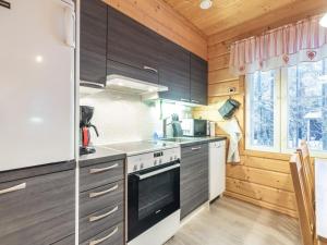 a kitchen with wooden cabinets and a stove top oven at Holiday Home Simeoni by Interhome in Äkäslompolo