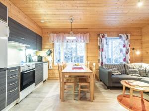a kitchen and living room with a table and a couch at Holiday Home Simeoni by Interhome in Äkäslompolo