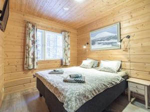 a bedroom with a bed in a wooden room at Holiday Home Simeoni by Interhome in Äkäslompolo +5 photos