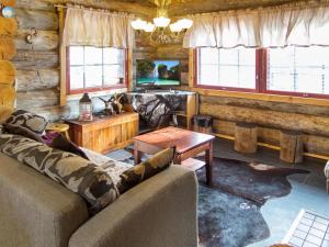 a living room with couches and a table and windows at Holiday Home Äkäsranta by Interhome in Äkäsjoensuu +23 photos