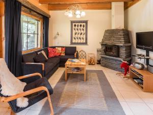 a living room with a couch and a fireplace at Holiday Home Sapara c10 by Interhome in Äkäslompolo